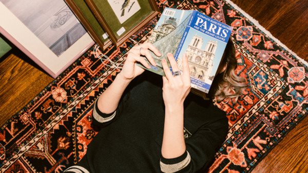 Kvinna läser guidebok om Paris. 