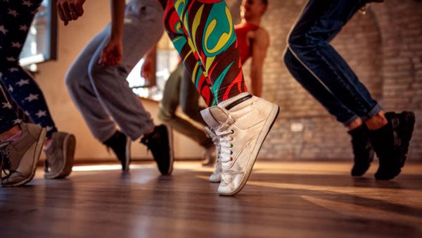 Fem personer i färglada danskläder dansar - gå en kurs i dansmix!