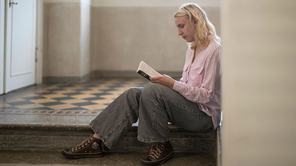 Ej tjej som sitter på biblioteket och studerar.