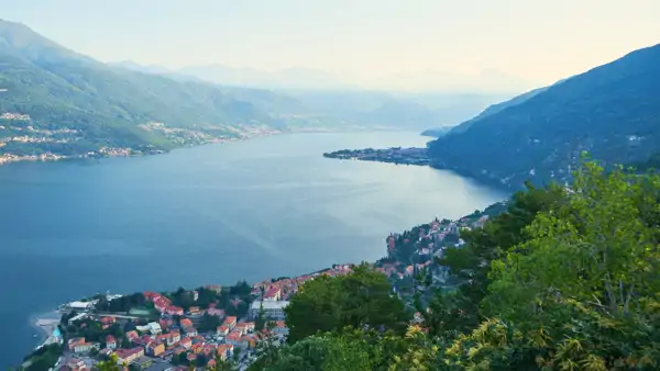 En vacker utsikt över en sjö omgiven av berg-Läs Italienska med Internationella skolorna i Como