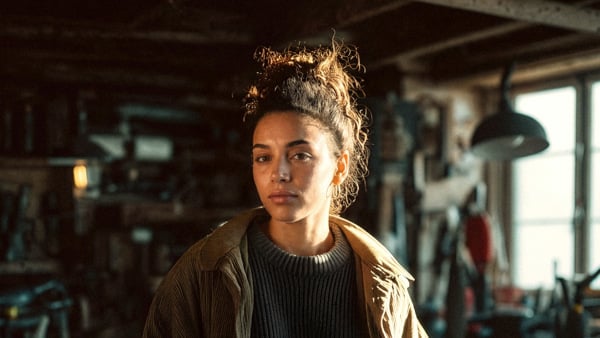 En kvinna som står i ett rum fullt av verktyg.