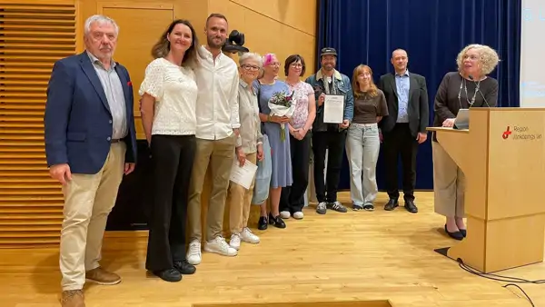 Personer inom projektet Kulturella upplevelser tar emot ett pris