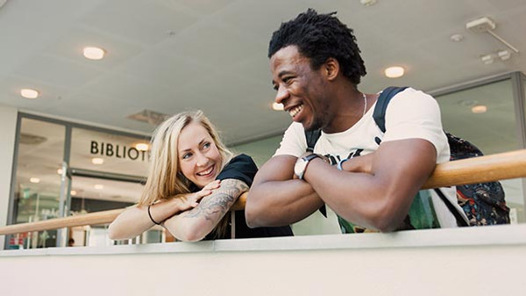 En man och en kvinna lutar sig mot ett räcke.