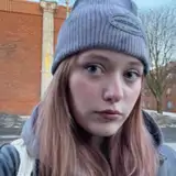 En kvinna som har en grå mössa