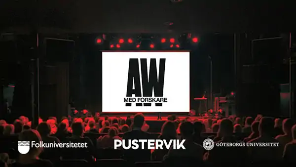 En folkmassa som sitter framför en skärm.