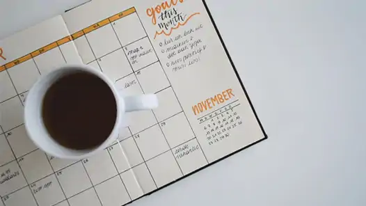 En kopp kaffe som står på en kalender.