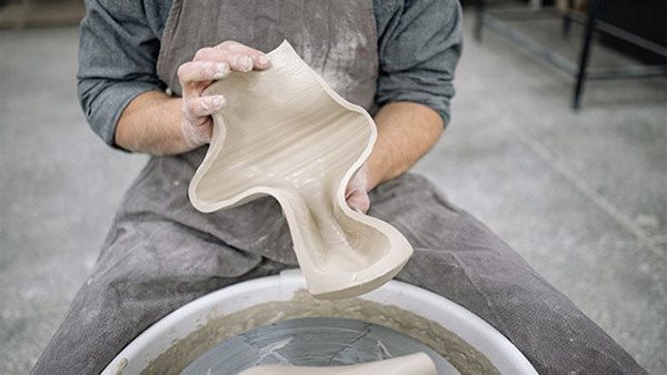Fotografi föreställande man som arbetar med keramik.