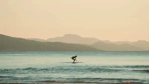En person som surfar på havet i Biarritz. Läs franska i Frankrike.