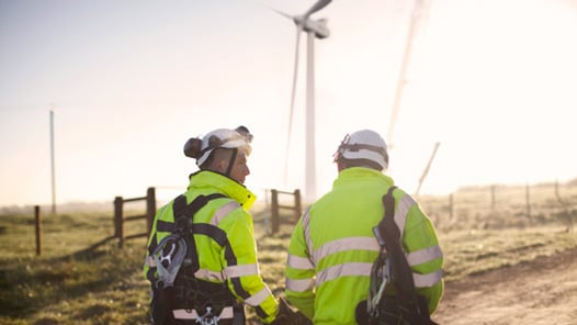 Två människor i varselkläder promenerar utomhus 