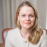 En kvinna som sitter i en stol med en bok i knät.