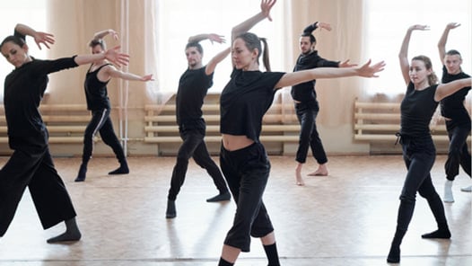 En grupp människor som står på toppen av ett dansgolv.