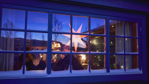 Barn i fönster med adventsstjärna