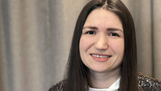 En kvinna med brunt hår som ler