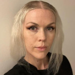 En kvinna med blont hår och svart skjorta.