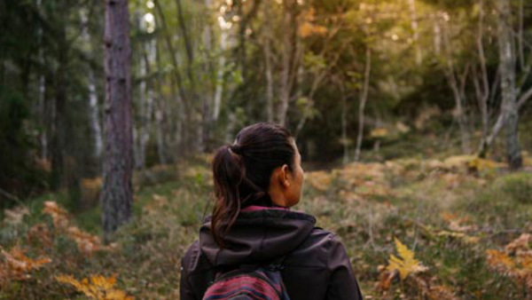 Kvinna som är ute i skogen på hösten