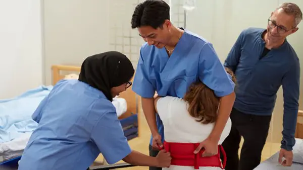 Elever på vård- och omsorgsprogrammet tränar på att hjälpa en patient med lyftbälte