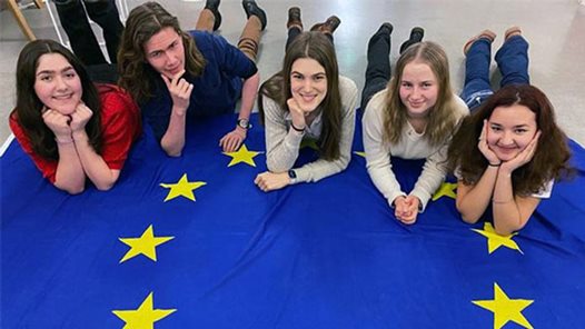 Kungstensgymnasiets EU-ambassadörer poserar på EU-flaggan