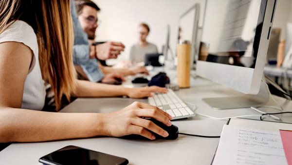 Deltagare arbetar tillsammans vid datorer i ett klassrum - problemlösning under en kurs i matematik