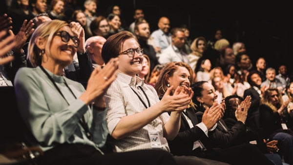 Applåderande leende publik under seminarium