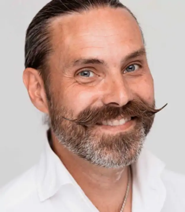 En man med mustasch i ansiktet.