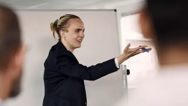 A woman standing in front of a whiteboard giving a presentation.