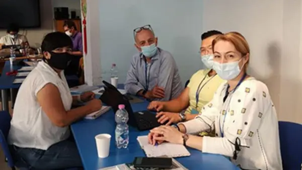 Fyra projektdeltagare runt ett bort, alla if&ouml;rda munskydd p&aring; grund av covid