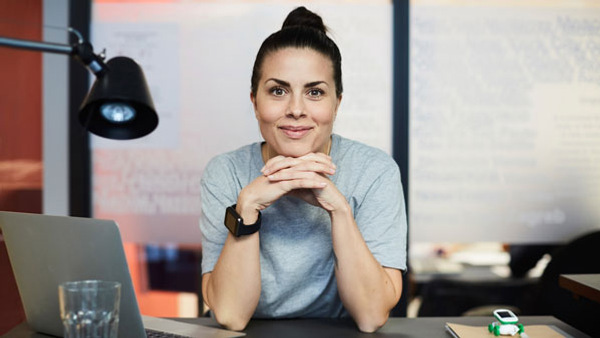 Kvinna sitter vid skrivbord, redo för en distanskurs via Folkuniversitetet.