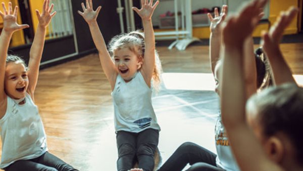 Teacher and group of children exercising dancing and ballet in dance school