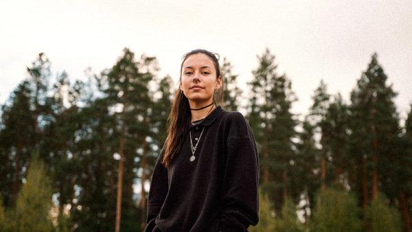 En kvinna som står mitt på en parkeringsplats.