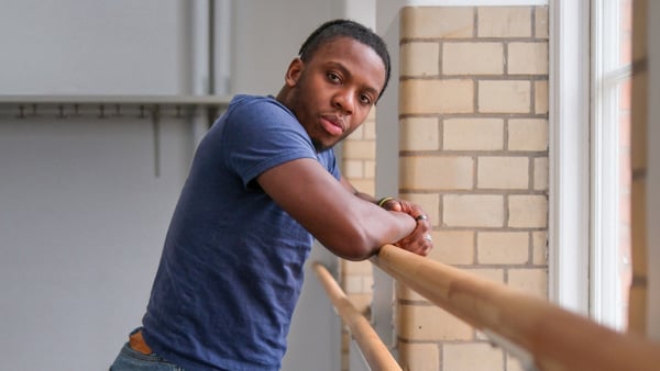 En man som står bredvid ett fönster.