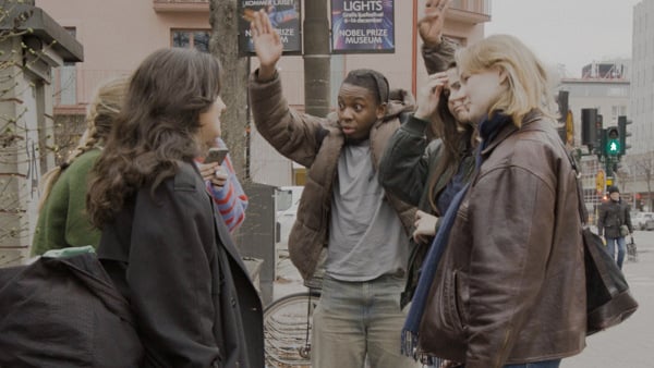 En grupp människor som står bredvid varandra på en trottoar.