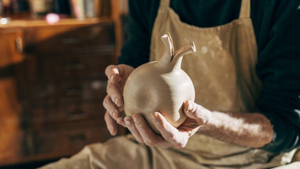 En person som håller en vas i sina händer.