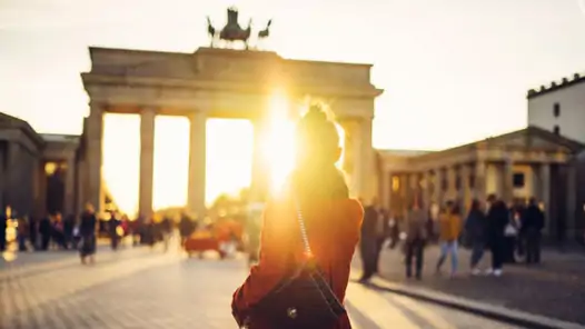 En kvinna går längs en gata framför Brandenburger Tor