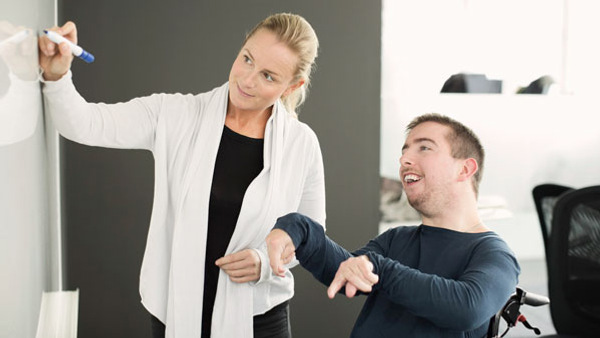 Lärare ritar på tavlan för elev i behov av extra stöd