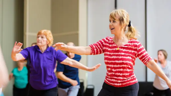 En grupp äldre kvinnor dansar på en dansklass.