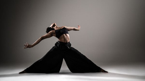 Dansare i svarta kläder som sträcker sig bakåt på Balettakademien Stockholm
