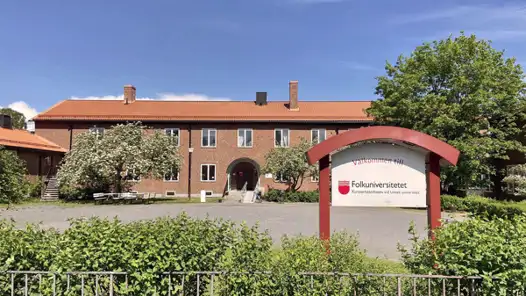 En stor tegelbyggnad med rött tak.