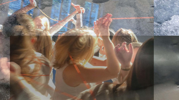 Dansare i vita kläder med ett rött snöre mellan sig