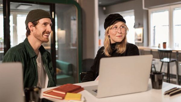 Två studerande vid ett bord på Folkuniversitetets diplomutbildningar