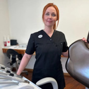 En kvinna som står bredvid en hårtork.