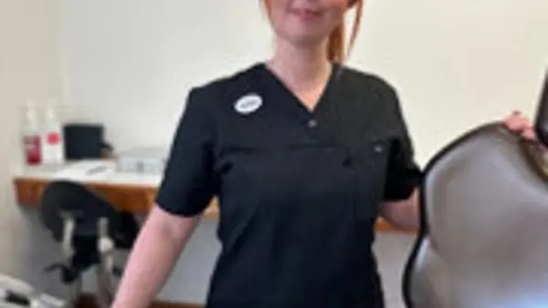 En kvinna som står bredvid en hårtork.