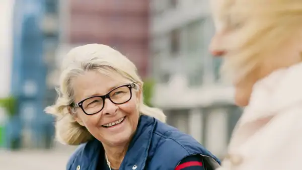 En kvinna med glasögon pratar med en annan kvinna.