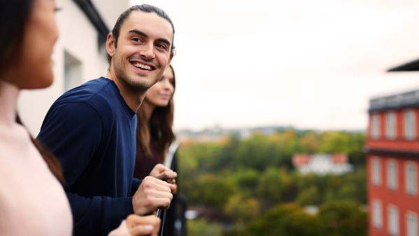 Medarbetare hos Folkuniversitetet på en balkong