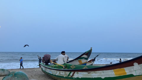 Tre färgglada fiskebåtar vid havet i Mahabalipuram