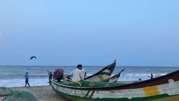 Tre f&auml;rgglada fiskeb&aring;tar vid havet i Mahabalipuram