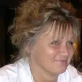 En kvinna med blont hår ler mot kameran.