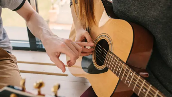 Två händer som spelar piano – gå en sommarkurs i musik på Folkuniversitetet.