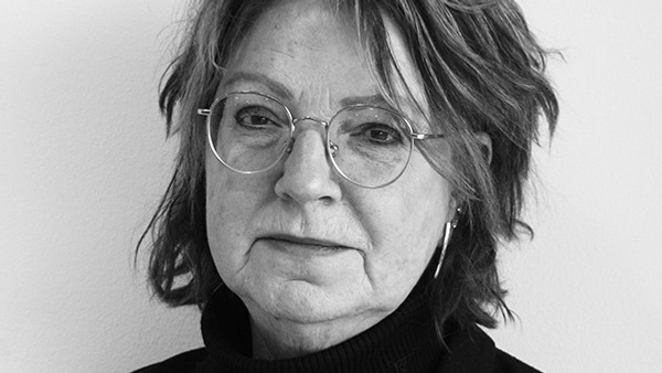 Ett svartvitt foto av en kvinna som bär glasögon.