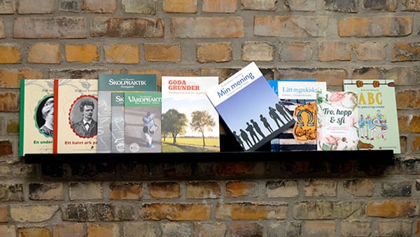 Folkuniversitetets förlags böcker på bokrean 2026 – en tegelvägg med en massa böcker på en hylla.