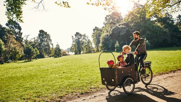 En familj på cykeltur en solig sommardag